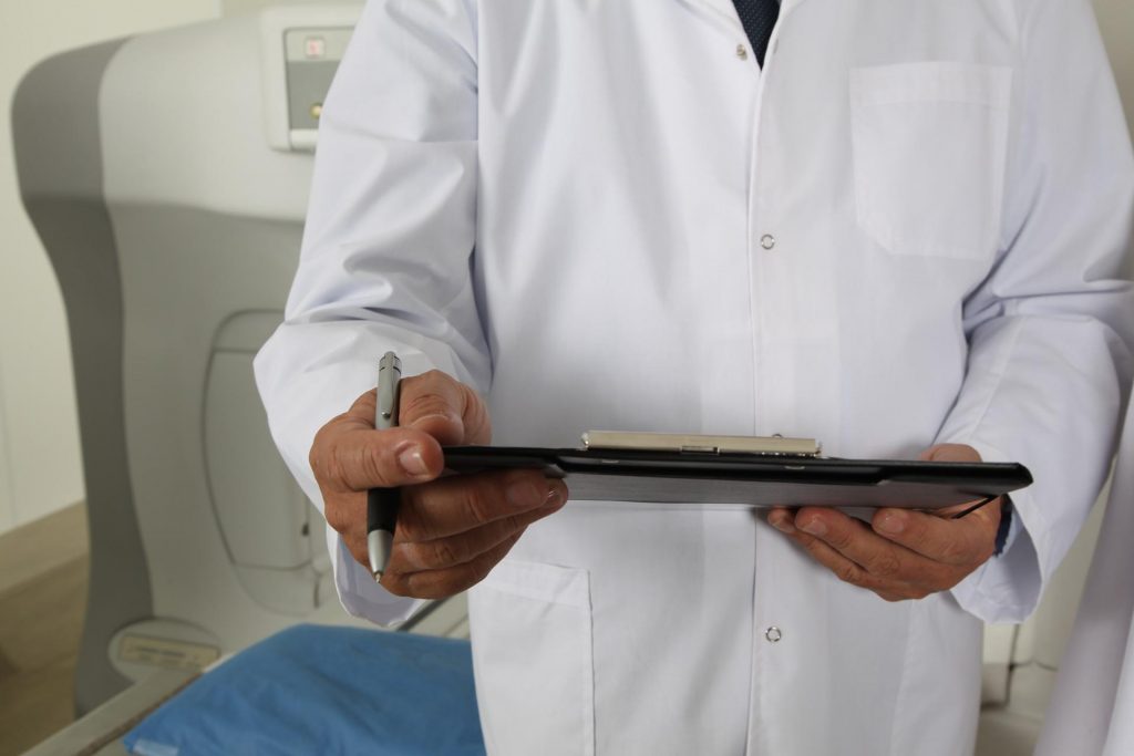 Lekarz w białym fartuchu trzymający kartę leczenia dystymii